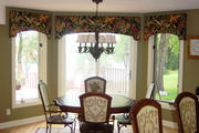 Kitchen bay window with arched cornices in a tropical print with a black background.
