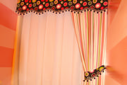 Pink bathroom with horizontal stripes, pink and black topper with striped curtain
