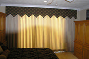 Master bedroom with gold drapes, black and gold bedspread and valance
