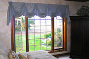 Blue Silk drapery with sheers mounted on wrought iron rods, blue and gold bedding in master
