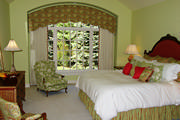 Quilted Valance on an arched window in Green, cream and coral accents with cream drapes, pillows, reupholstered chairs 
