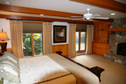 Rustic Master bedroom, French pleated plaid drapes mounted on brown wrought iron rods with pleated shades.
