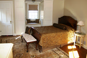 Gold and brown tailored bedding with silk bolster and pillows for a master bedroom
