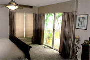Taupe silk bedroom drapery mounted under box cornice with covered buttons.
