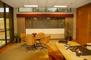Office window with padded cornice and banded side drapes all to soften the look of all that wood.
