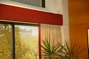 Office window with padded cornice and banded side drapes up close.
