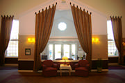 These two story window treatments of this assisted living center are mounted on iron tab posts and the drapery is an embroidered faux silk.
