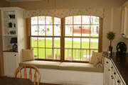 Arching valance over a window seat coordinates with the pillows and cushion.

