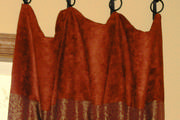 Close up of the banding area of the drapes with sewn on rings hanging on wrought iron hooks from Helser Brothers.
