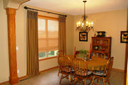 Drapes with banding along top in a black and gold check with the main fabric in a gold linen.
