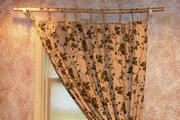 In this cute cottage window a birch branch was used for the tied back drapery.
