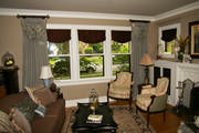 Goblet pleat drapes with toile swags frame the living room windows. 
