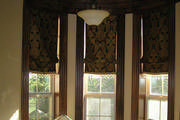 Classic roman shades in a heavy gold and black damask give this office a stately feel.
