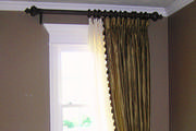 Striped silk drapes with goblet pleats over sheers are mounted on 21/2 inch wood pole.
